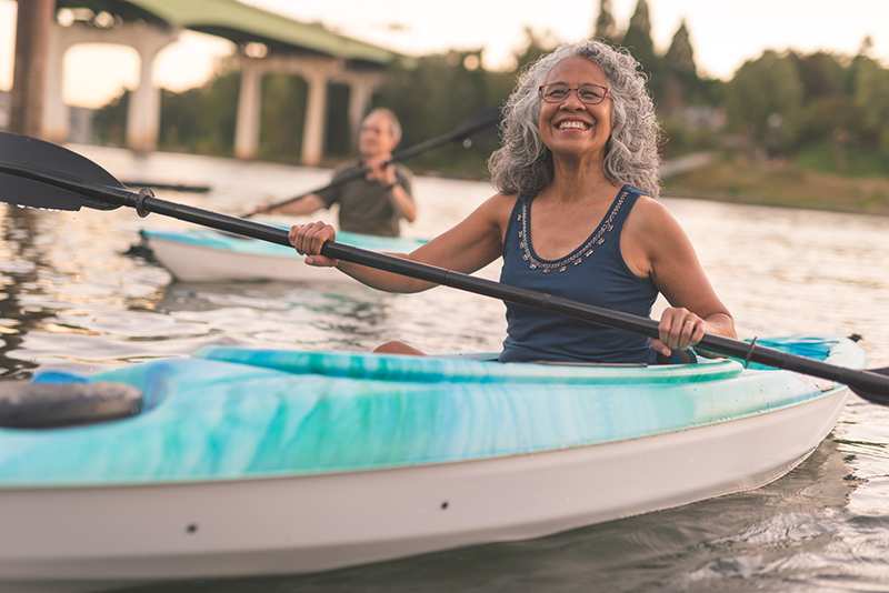 An older couple enjoy a late evening of kayaking on the river